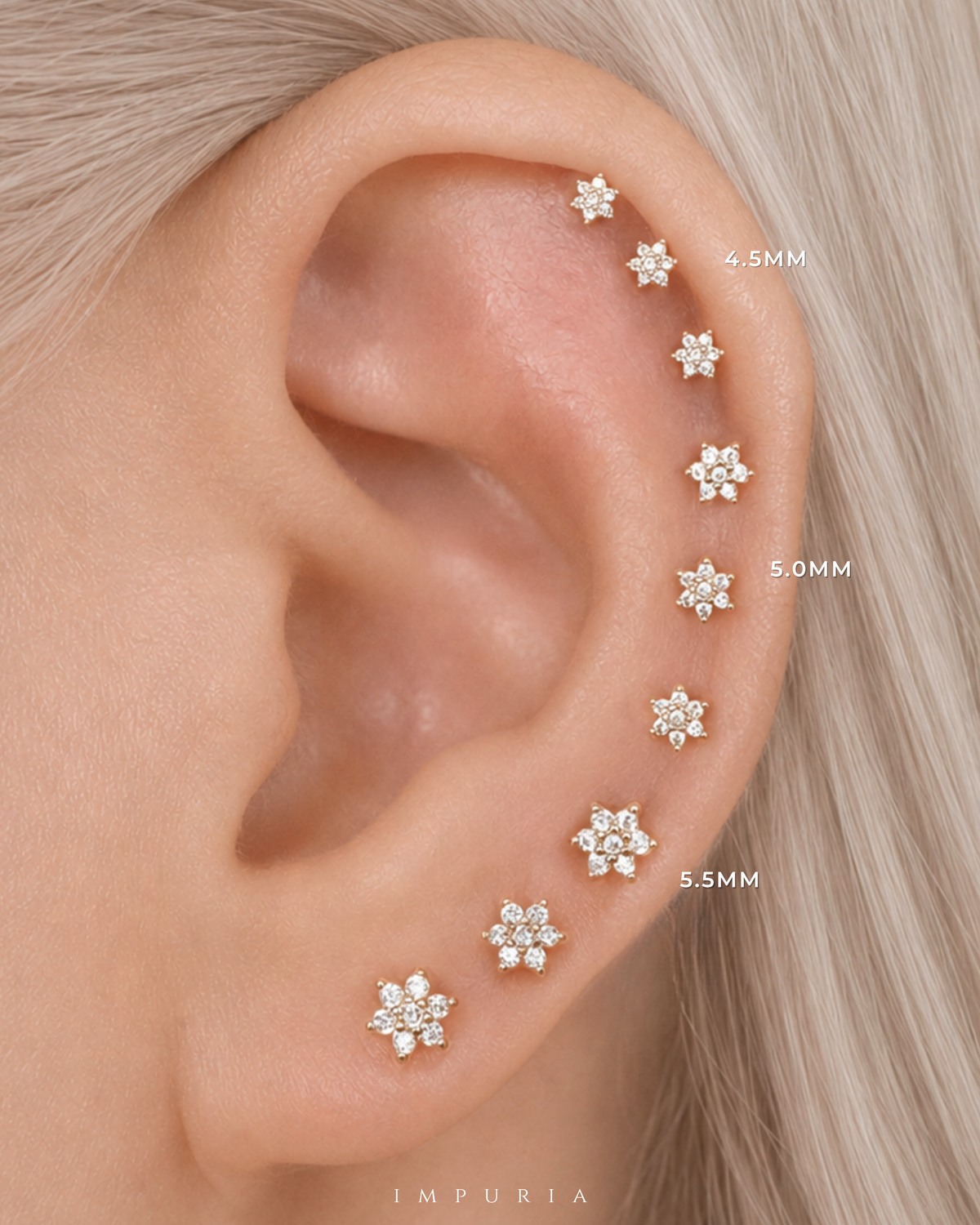 Close-up of a person's ear wearing a series of small flower-shaped stud earrings in graduated sizes labeled 4.5MM, 5.