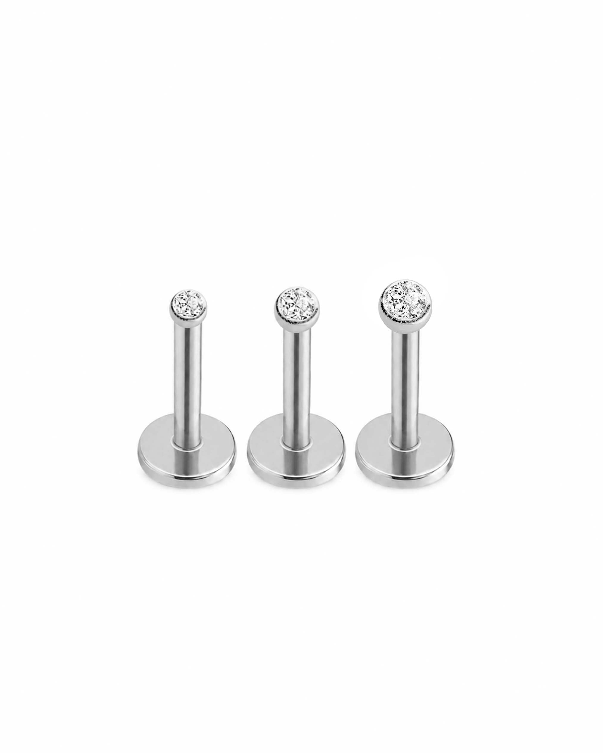 Three silver flat-back labret studs with clear gemstones, arranged in a row against a solid white background.