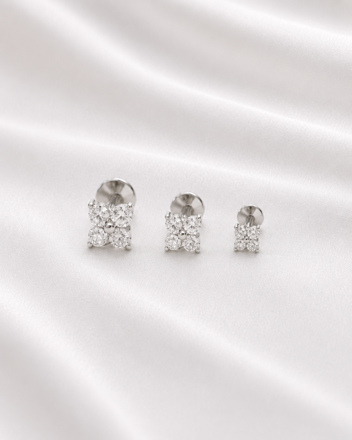 Surgical steel clover flat back stud earring available in multiple sizes, designed for everyday wear and various piercing placements.