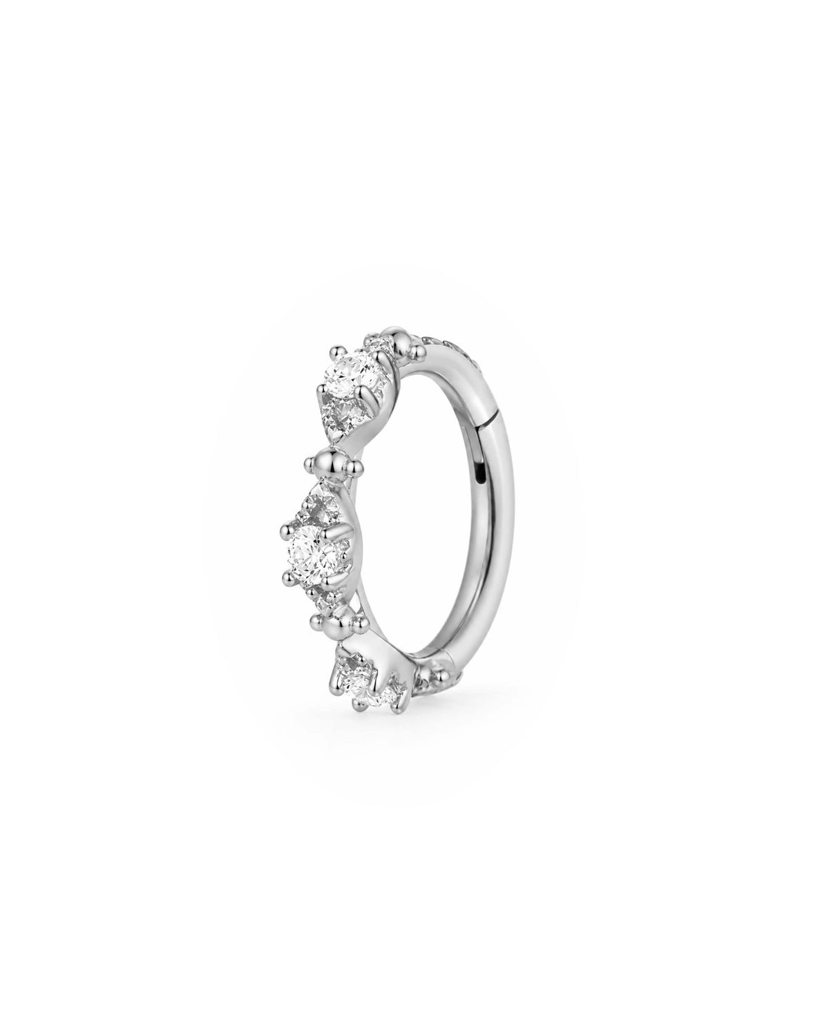 A silver migraine hoop ring clicker decorated with four small clear gemstones in a prong setting, shown on a plain white background.