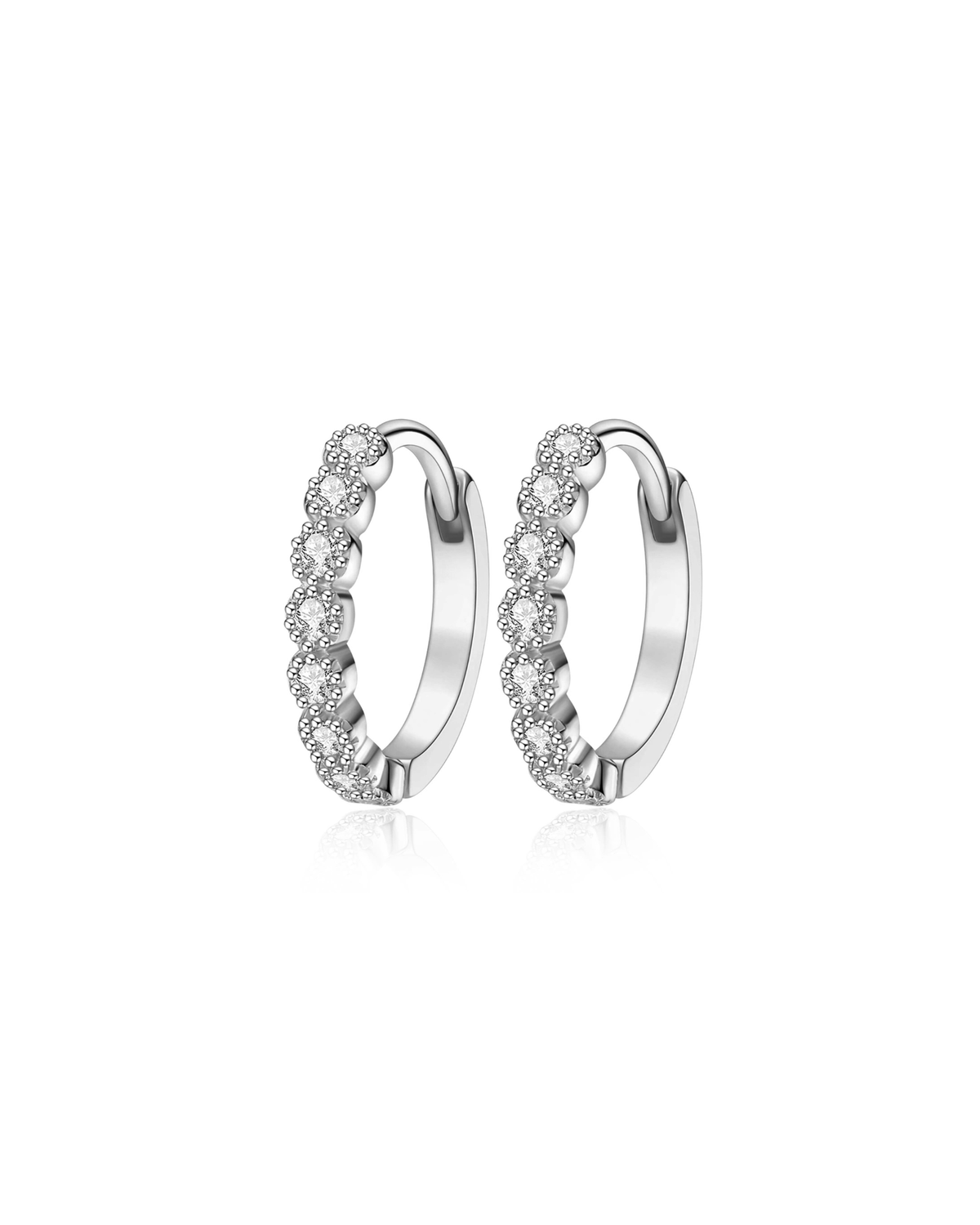 A pair of silver huggie hoop earrings adorned with a continuous row of small clear pavé-set stones, shown on a clean white background with a subtle reflection.