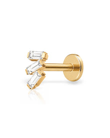 A gold post piercing stud with three baguette-cut clear gemstones, shown on a clean white background with a soft reflection.