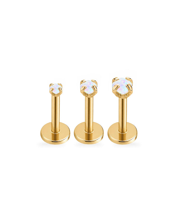Three gold-tone labret piercing studs with round bezel-set iridescent opal white gemstones, arranged in ascending size on a plain white background.